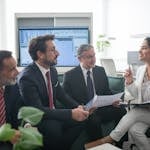 Diverse business professionals engaged in a lively office meeting, fostering collaboration and teamwork.