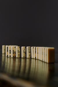 A domino effect with a tiny tile starting a chain reaction of increasingly larger tiles, symbolizing small habits leading to big results.
