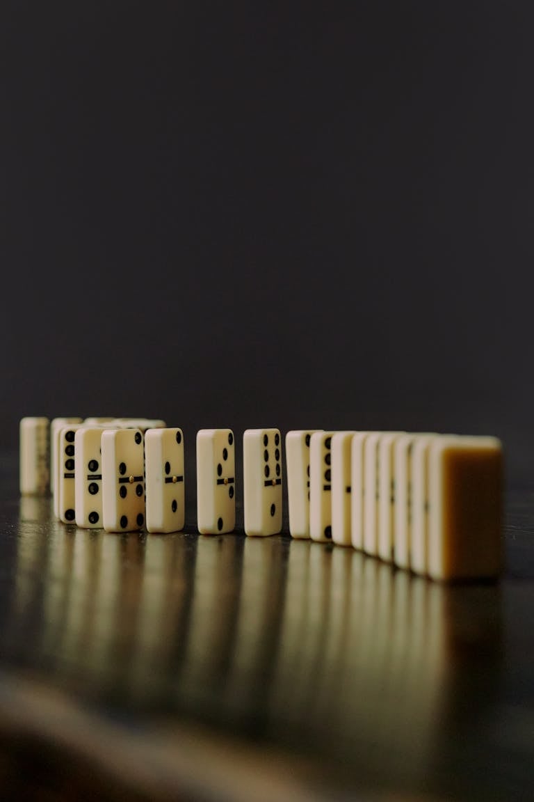A domino effect with a tiny tile starting a chain reaction of increasingly larger tiles, symbolizing small habits leading to big results.