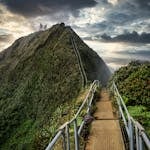 A staircase with tiny labeled steps leading to a large mountain summit.