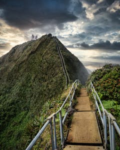 A staircase with tiny labeled steps leading to a large mountain summit.