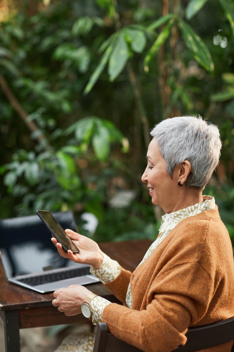 A person using technology outdoors, with nature in the background