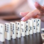 A domino effect starting with a small tile leading to larger ones, symbolizing habit momentum.