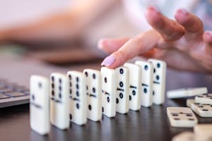 A domino effect starting with a small tile leading to larger ones, symbolizing habit momentum.