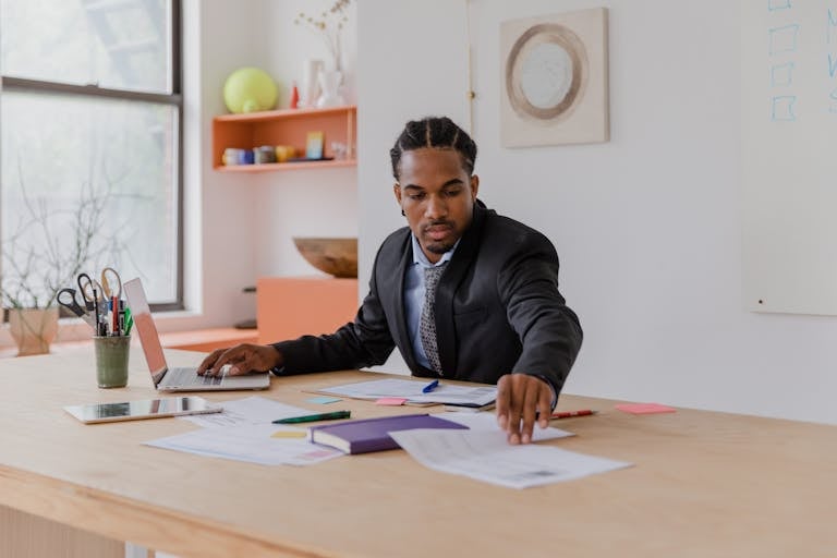 A focused entrepreneur working at their desk with a planner, clock, and multiple tasks on a to-do list to emphasize productivity and time management.