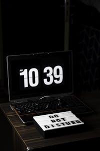A peaceful workspace with a clock, notebook, and a "Do Not Disturb" sign, surrounded by blurred social media icons fading away.