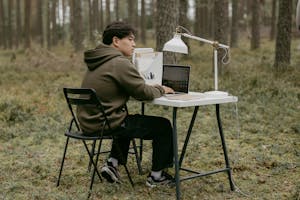 A person at a minimalist desk, working on a laptop with no notifications, surrounded by greenery or natural light.