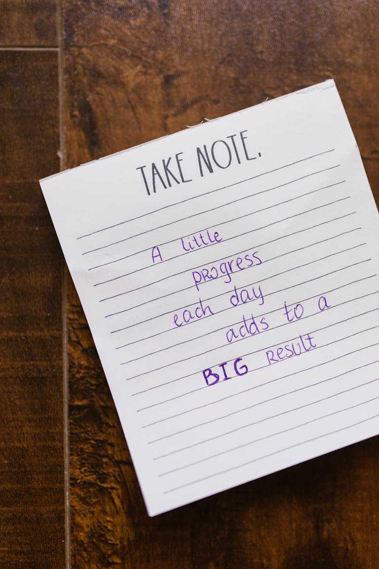 A person writing in a journal with motivational quotes and goal-setting tools.