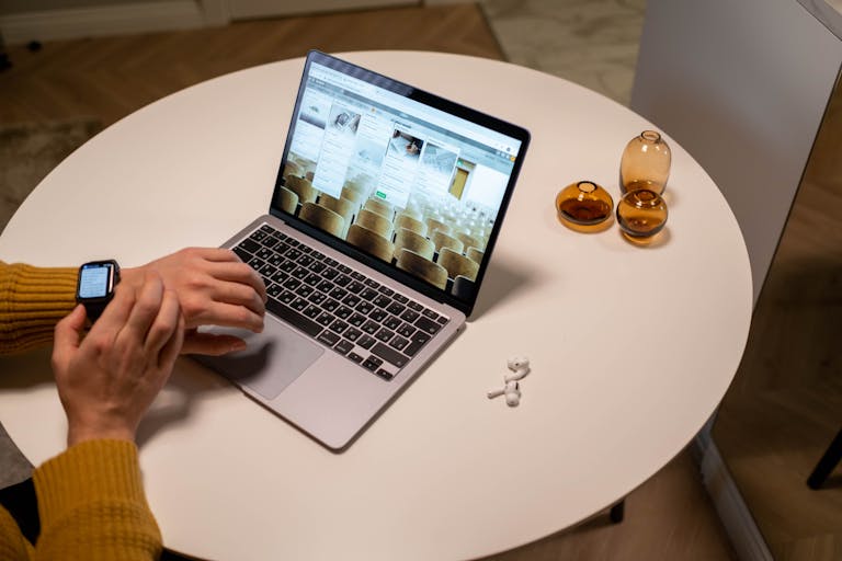A person working on a laptop with a timer beside them, symbolizing balance between productivity and screen time management.