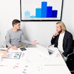 A businessperson analyzing data on a laptop with charts, graphs, and data visualizations in the background.