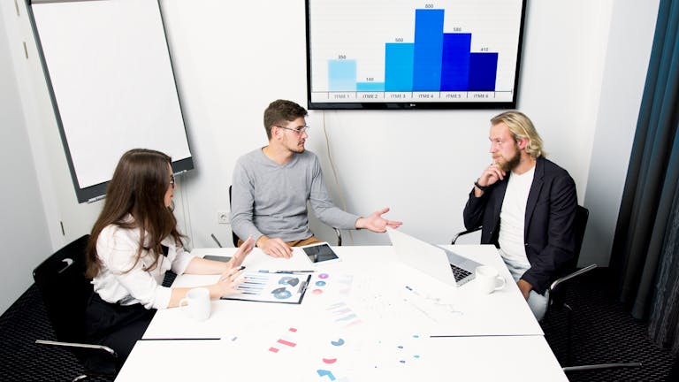A businessperson analyzing data on a laptop with charts, graphs, and data visualizations in the background.