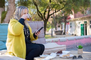 A person sitting peacefully in nature, phone off, journaling or sipping tea.