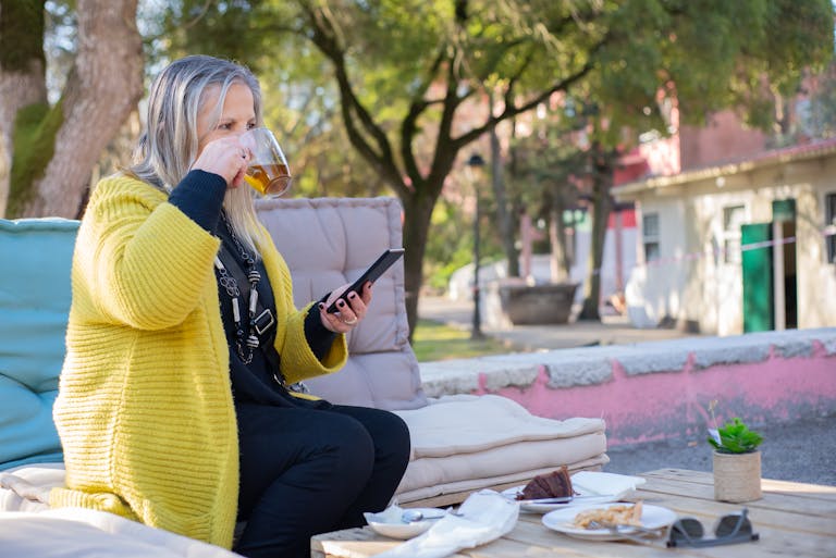 A person sitting peacefully in nature, phone off, journaling or sipping tea.