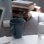 Sunrise light hitting a calm desk with a laptop, notepad, and cup of tea.