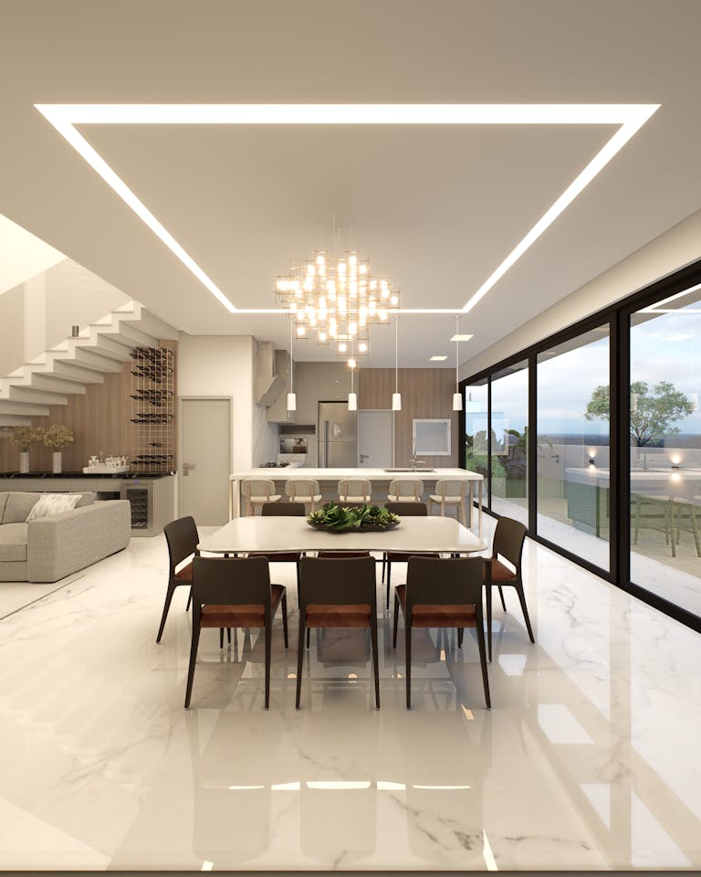 Sleek contemporary interior design featuring an open-plan kitchen and dining area with elegant lighting.