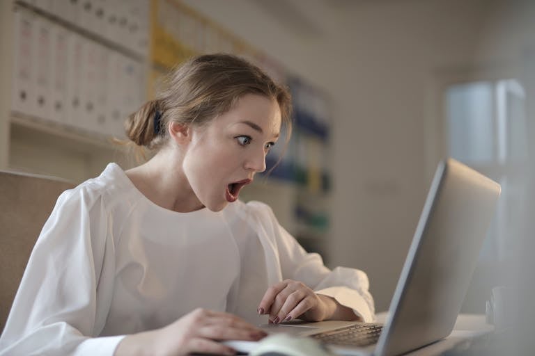A person sitting at a desk with a laptop, with their phone turned off and a focus timer on the screen.