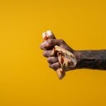 A hand breaking a chain with habit labels like “procrastination” or “junk food” written on it.