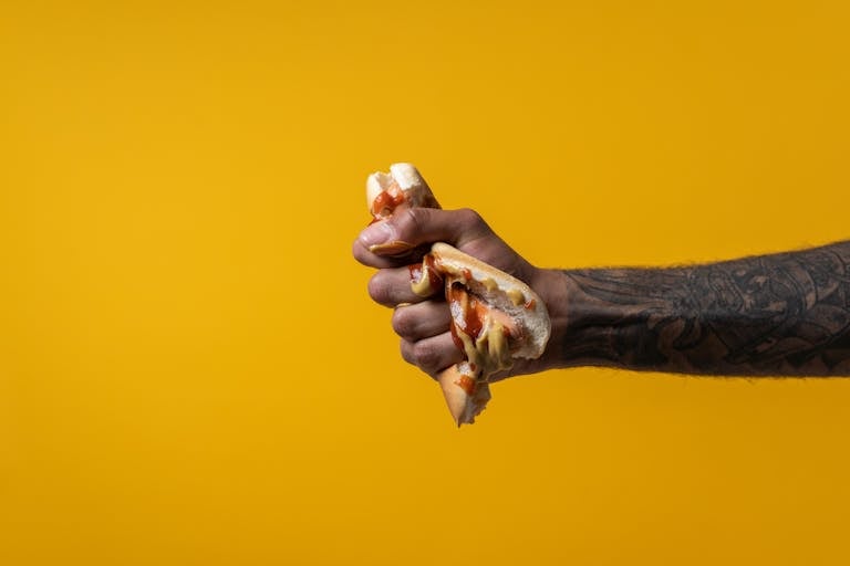 A hand breaking a chain with habit labels like “procrastination” or “junk food” written on it.