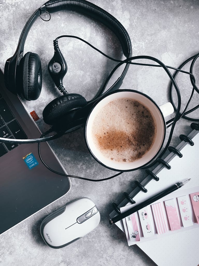 A digital notepad open on a tablet beside a calming cup of tea and headphones.