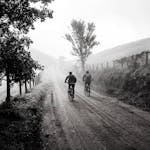 A person at a crossroads with one clear, confident path forward while other paths are foggy or tangled.