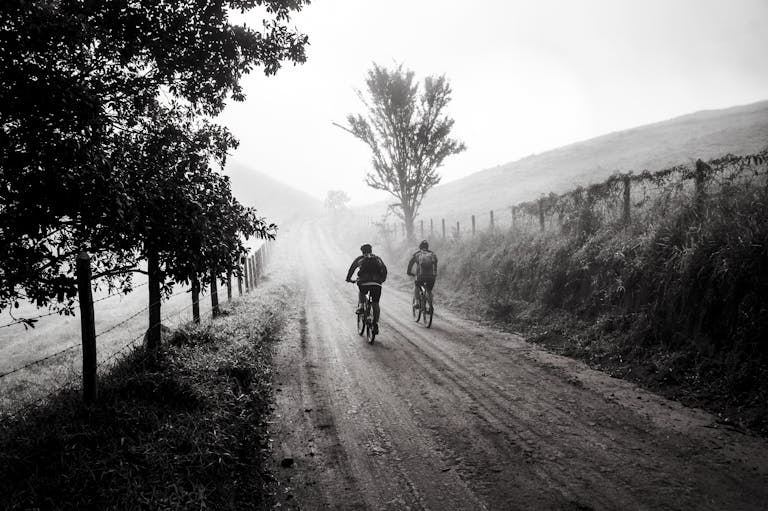 A person at a crossroads with one clear, confident path forward while other paths are foggy or tangled.
