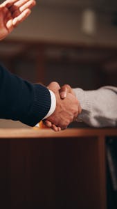A professional networking event or two individuals shaking hands in a business setting.