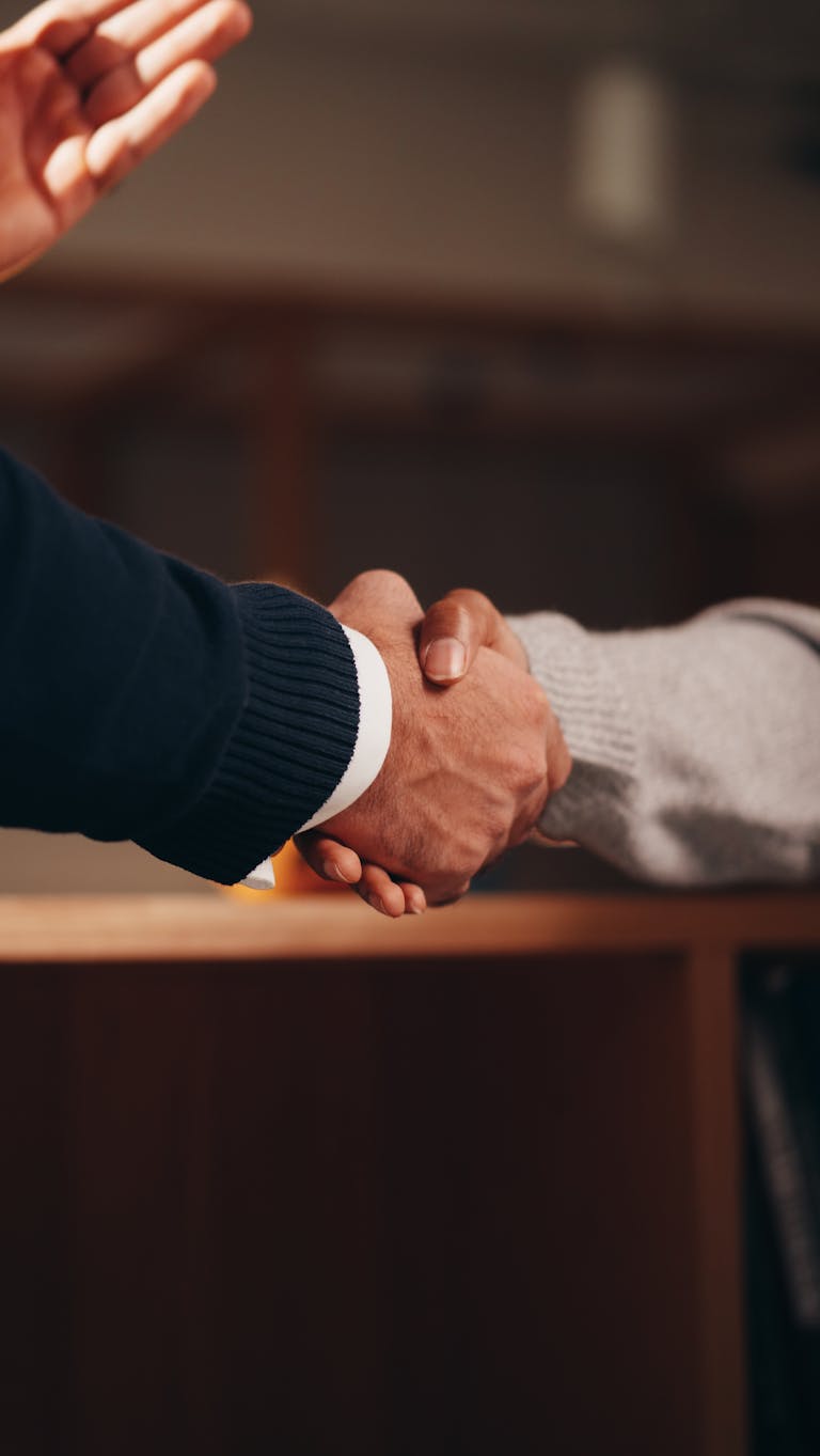 A professional networking event or two individuals shaking hands in a business setting.