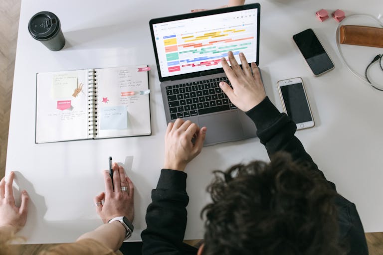 A person working at a desk with a phone turned off and only a laptop, illustrating digital focus.