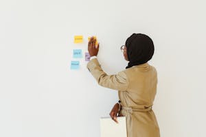 A person organizing sticky notes or a calendar with highlighted top priorities.