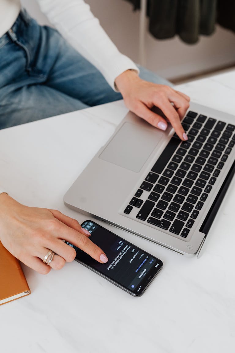 A person distracted by multiple screens and notifications while trying to work at a desk.