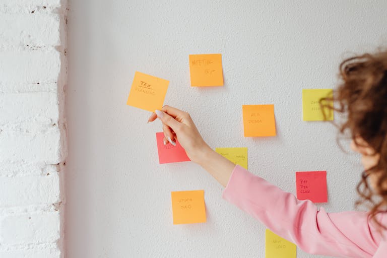 A person setting goals on a vision board or writing in a planner