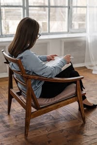 A person stretching or journaling with sunrise light coming through a window