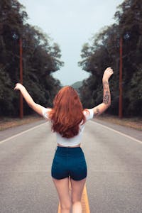 A determined person standing at the start of a long road with confidence