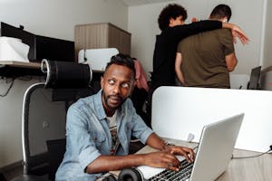 A person working intently at a desk, surrounded by a clutter-free environment.