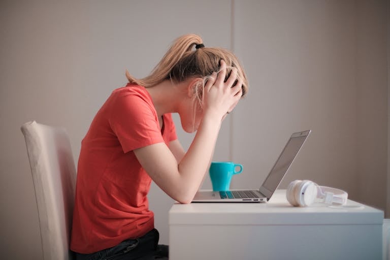 A stressed person surrounded by digital screens, emails, and notifications