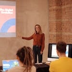 A person confidently presenting in front of an audience or sharing a story on social media with a professional but approachable demeanor.