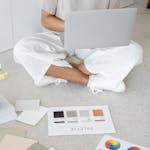 An entrepreneur confidently presenting themselves in front of a laptop, with their personal brand elements (logo, color palette) subtly integrated into their workspace.
