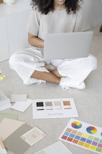 An entrepreneur confidently presenting themselves in front of a laptop, with their personal brand elements (logo, color palette) subtly integrated into their workspace.