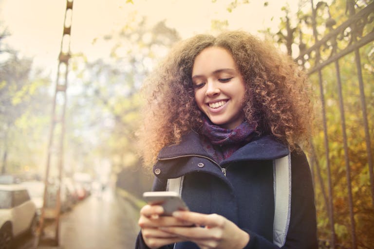 A person turning off their smartphone while enjoying a walk in nature.